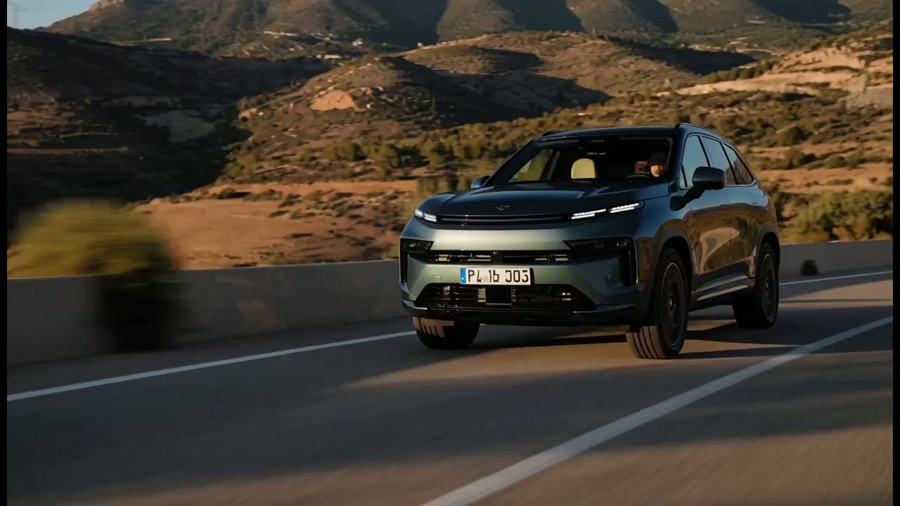 Blue-toned German SUV on a mountain road in warm sunset light